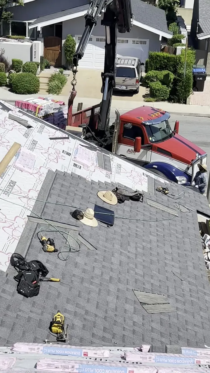 Pacific Roofing crew installing a new shingle roof, materials and tools on the deck